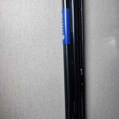 Dois tubos pretos com etiqueta azul e branca sobre superfície cinza claro