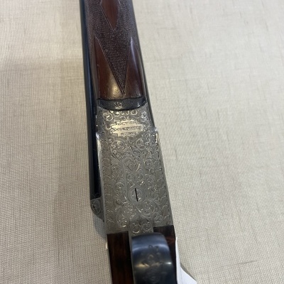 Parte próxima da coronha de arma de fogo em madeira e metal decorado