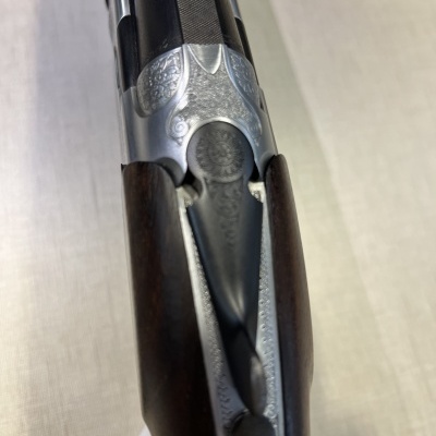 Espingarda com madeira escura e metal prateado gravado