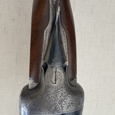 Espingarda com detalhes metálicos gravados e punho de madeira castanha