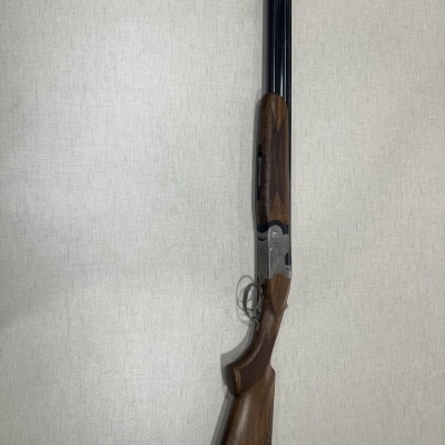 Espingarda de canos duplos com coronha em madeira castanha e canos pretos