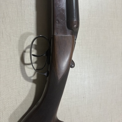 Espingarda de canos duplos com coronha em madeira escura e gatilhos metálicos