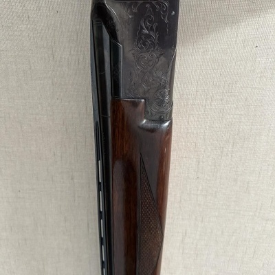 Espingarda de cano duplo com detalhes gravados e madeira castanha