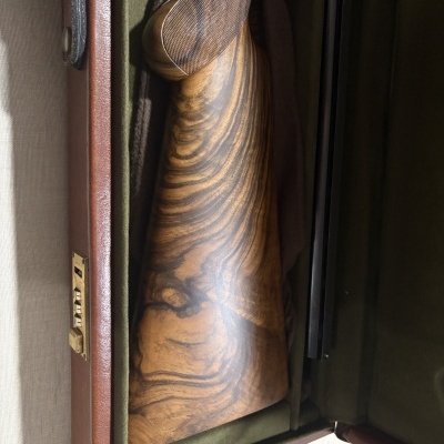 Coronha de madeira polida dentro de estojo verde