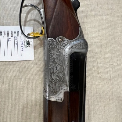 Espingarda com coronha em madeira e detalhes gravados em metal prateado