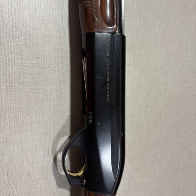 Espingarda de caça em madeira e metal preto com gatilho dourado