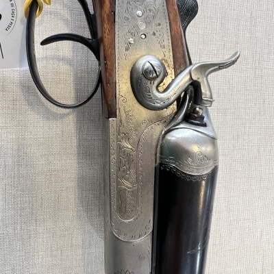 Espingarda de cano duplo com gravações decorativas em metal e madeira