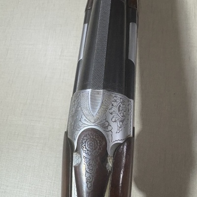 Espingarda de canos duplos com decoração gravada e madeira polida