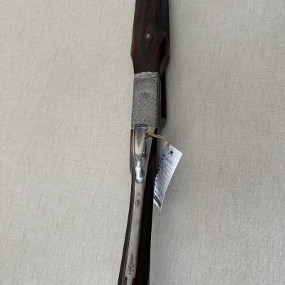 Espingarda de caça com coronha em madeira escura e caixa metálica gravada