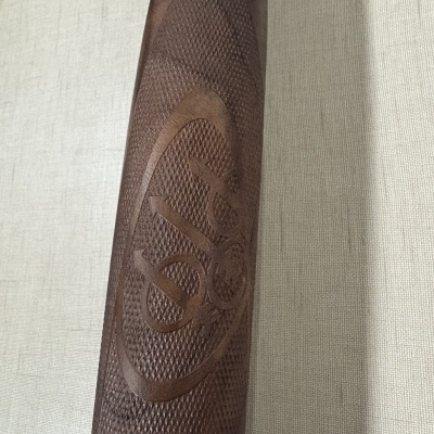 Empunhadura de madeira castanha escura com gravação do logotipo DIA