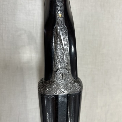 Espingarda dupla com detalhes metálicos gravados e madeira preta