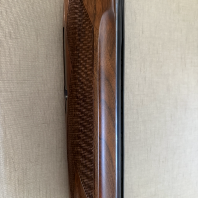 Base de madeira castanha escura com padrão texturizado e cano metálico preto ao lado