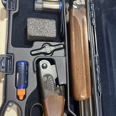 Caixa aberta com espingarda Beretta desmontada e acessórios