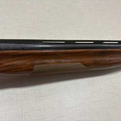 Escopeta com madeira castanha e metal preto com texto gravado