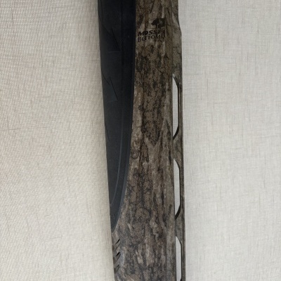 Parte de arma de fogo camuflada com detalhes em preto e texto MOSSY BOTTOM