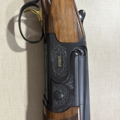 Espingarda de canos sobrepostos com detalhe em madeira e metal negro gravado