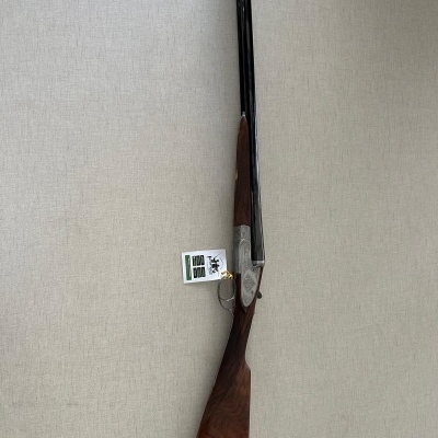 Espingarda de canos duplos com coronha de madeira castanha e canos pretos