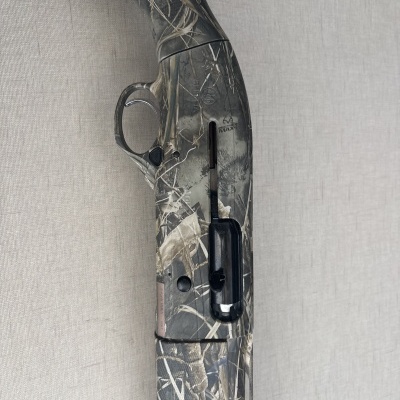 Espingarda camuflada com texto BIALTRA MAX contra fundo cinza