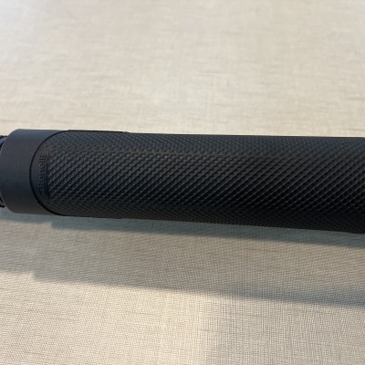 Peça cilíndrica preta com textura malha antiderrapante sobre tecido bege