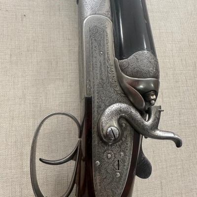 Espingarda de canos duplos com detalhes em metal gravado e madeira escura