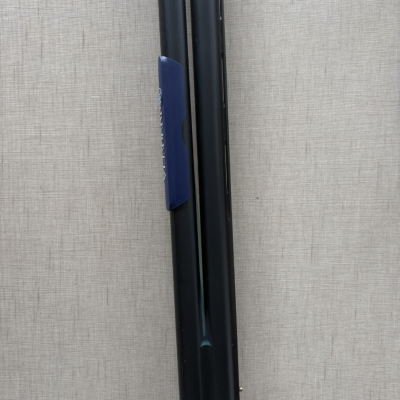 Objeto metálico preto com peça azul e texto branco parcialmente visível