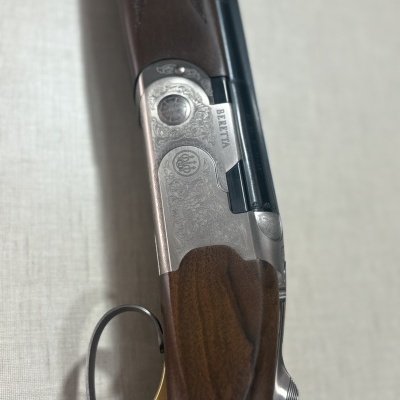 Espingarda Beretta em madeira e metal com gravações detalhadas e gatilho dourado