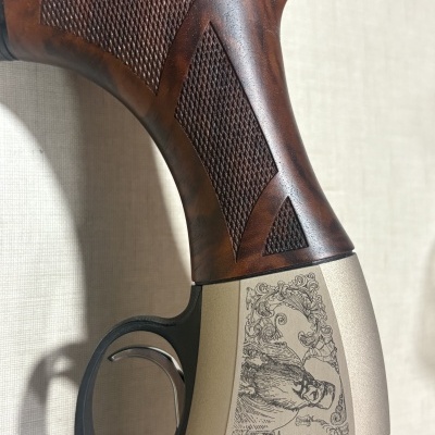 Cabo de madeira e parte metálica decorada de arma