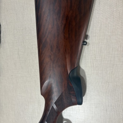 Coronha de arma de fogo em madeira castanha com detalhes pretos e gravação metálica Beretta