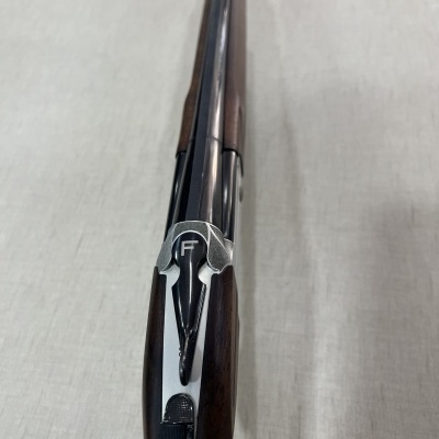 Espingarda com coronha de madeira e cano metálico vista de cima