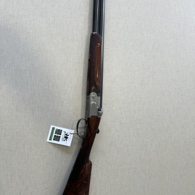 Espingarda de caça com canos metálicos pretos e coronha de madeira escura