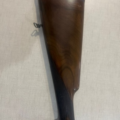 Coronha de espingarda em madeira escura com detalhes em preto e bochecha almofadada vermelha