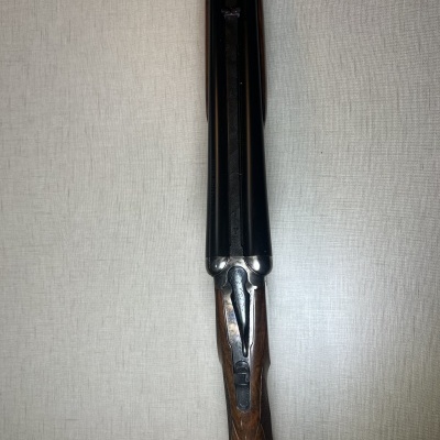 Espingarda de canos duplos com coronha de madeira sobre fundo claro