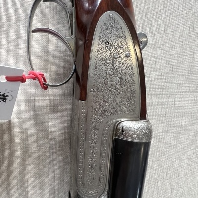 Rifle com detalhes metálicos gravados e coronha de madeira