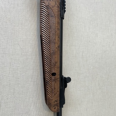 Cano de arma com coronha em madeira trabalhada e corpo metálico preto