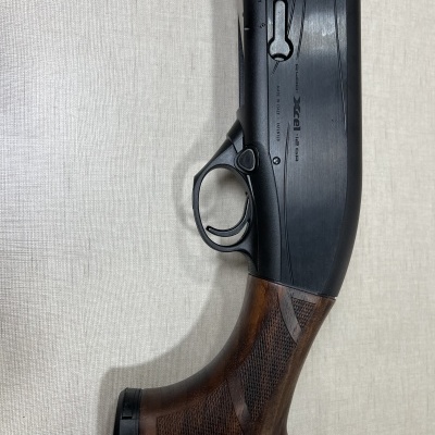 Espingarda com coronha de madeira castanha e corpo metálico preto