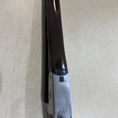 Espingarda de canos paralelos com detalhes em madeira e metal gravado