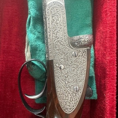 Arma de fogo com detalhes gravados em metal e madeira