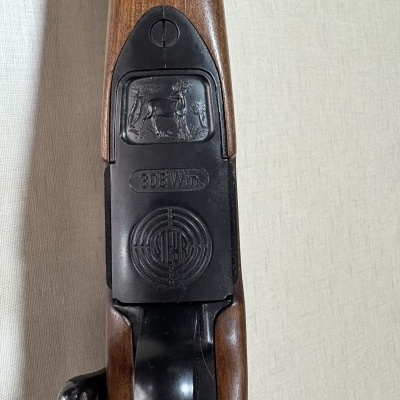 Parte traseira de arma de fogo com relevo de cervo e inscrições 308 Win.