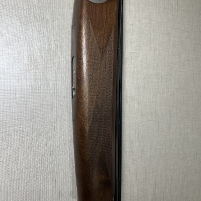 Espingarda com madeira castanha e detalhes metálicos prateados