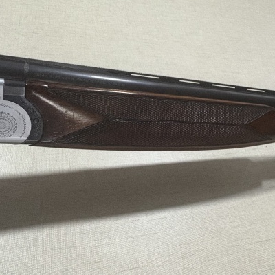 Espingarda com canos duplos e detalhes em metal prateado com madeira escura