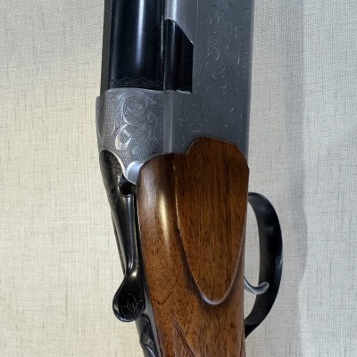 Espingarda de cano duplo com madeira castanha e acabamento metálico gravado