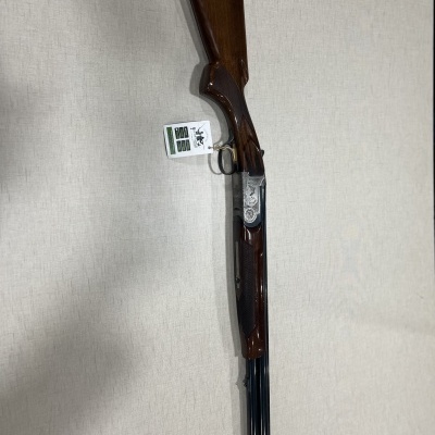 Espingarda de canos duplos com madeira castanha e detalhes metálicos