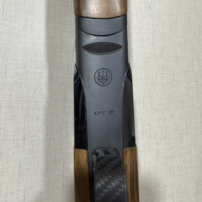 Parte central de caça-níqueis Beretta DT 11 em metal preto, madeira e fibra de carbono.