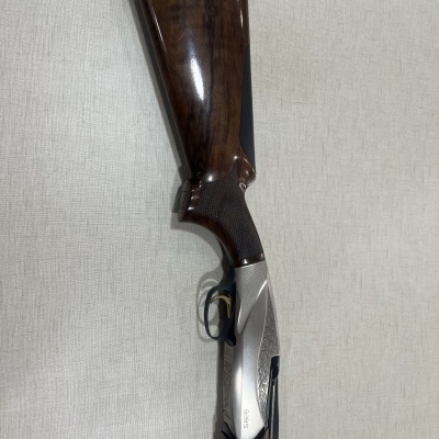 Espingarda com madeira castanha e metal prateado com número gravado