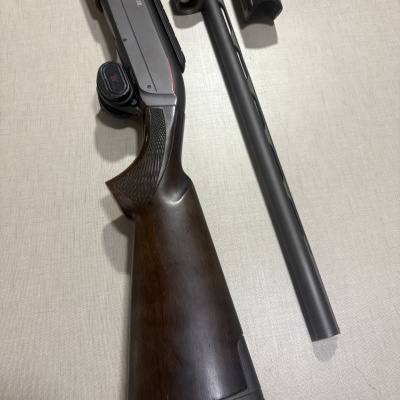 Espingarda de caça Winchester com madeira escura e cano metálico preto removível em fundo claro