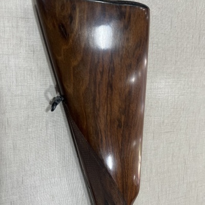 Coronha de madeira polida com textura quadriculada sobre fundo de tecido claro