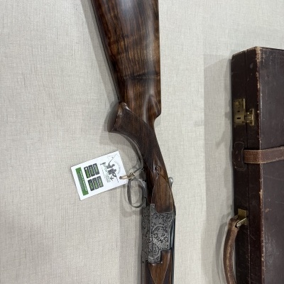 Espingarda de caça com coronha em madeira escura e estojo em couro castanho