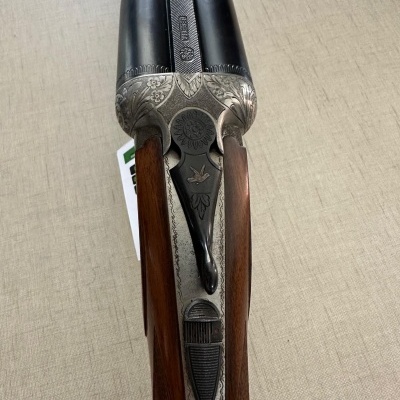 Espingarda de canos duplos em madeira com detalhes metálicos decorados