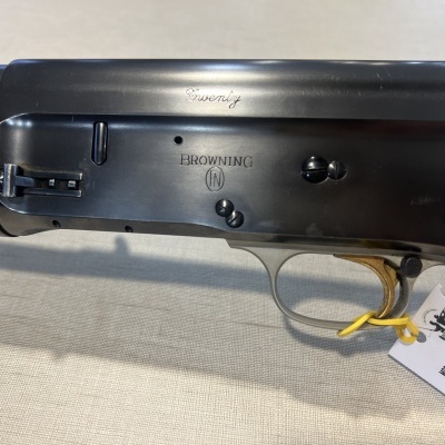 Rifle semiautomático preto com cabo de madeira castanha e etiqueta branca anexada