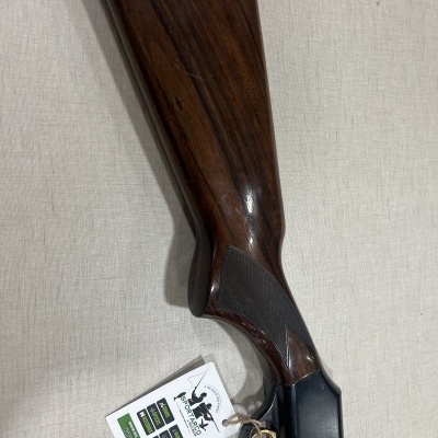 Coronha de espingarda em madeira e metal com etiqueta pendurada